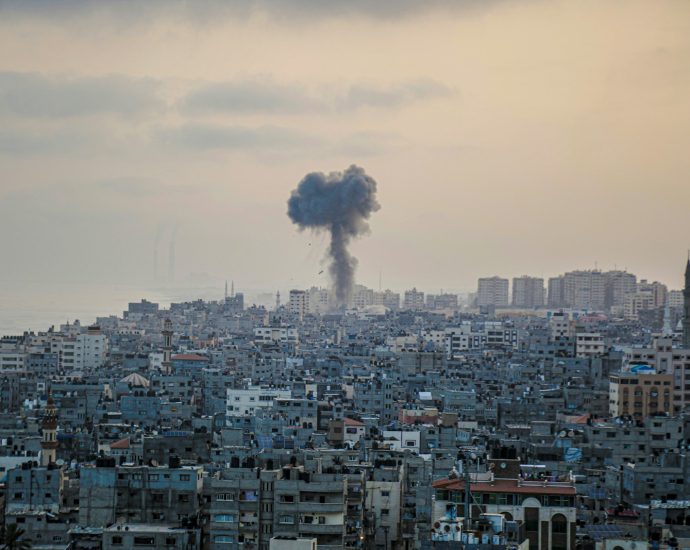 smoke billows from a factory in a city