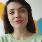 Young woman with blue eyes against colorful background