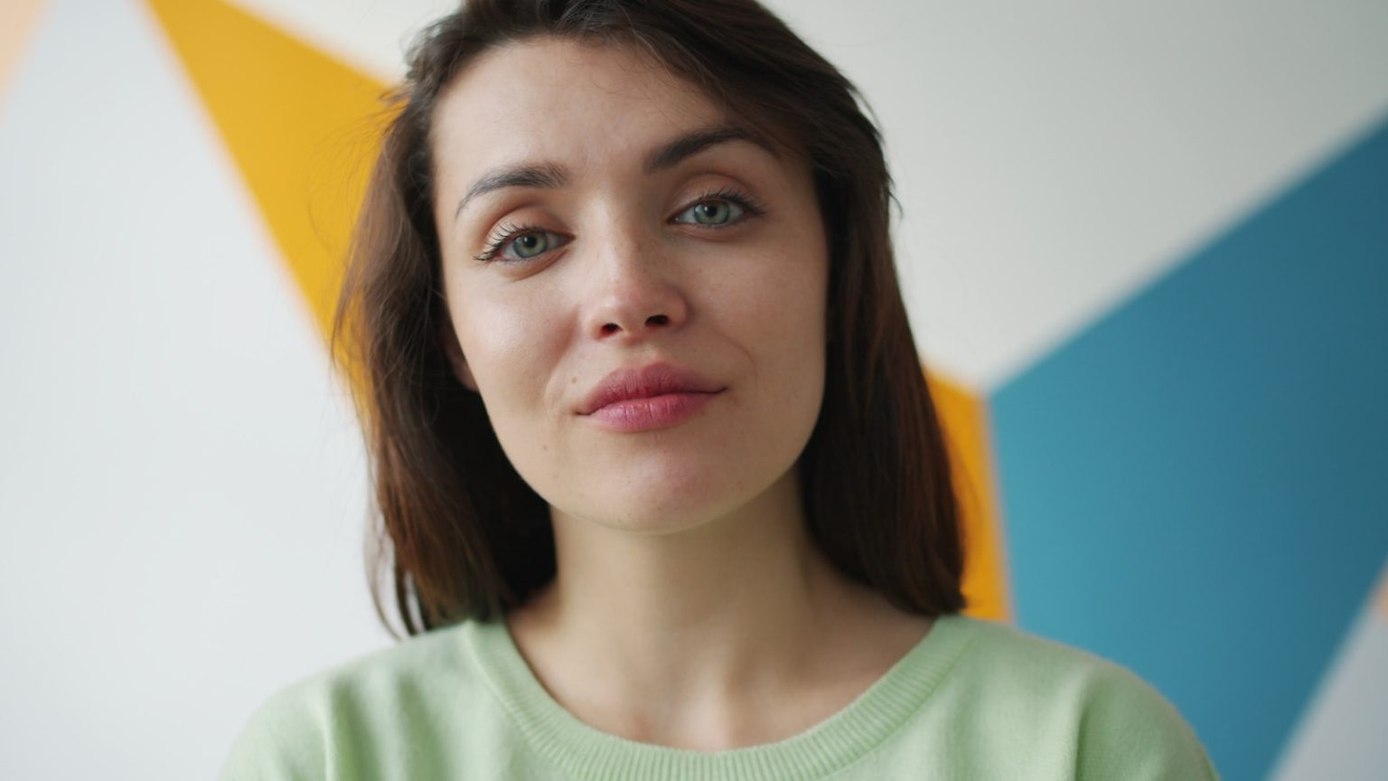 Young woman with blue eyes against colorful background
