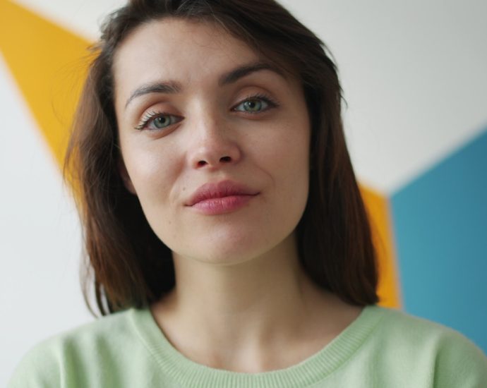 Young woman with blue eyes against colorful background