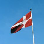 a red and white flag on a flagpole