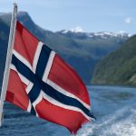 A flag flying from a boat in a body of water