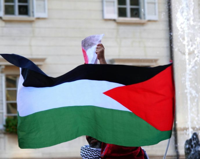 a person holding a flag in front of a building