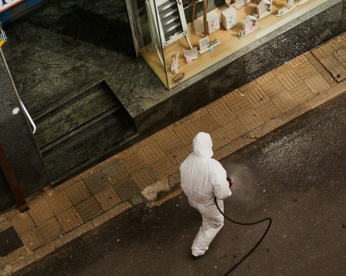 man in white thobe walking on sidewalk during daytime