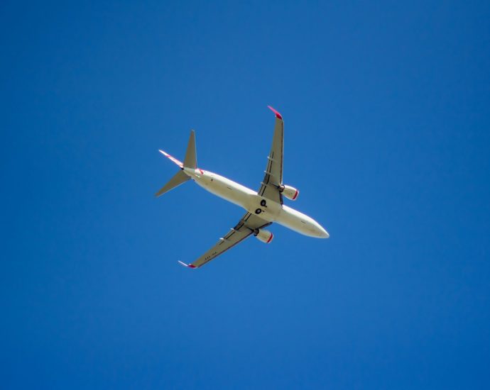 a large passenger jet flying through a blue sky