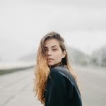 A young woman gazes towards the viewer.