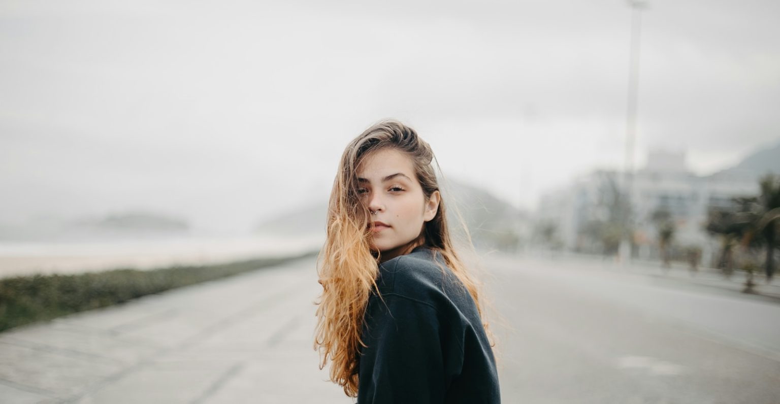 A young woman gazes towards the viewer.