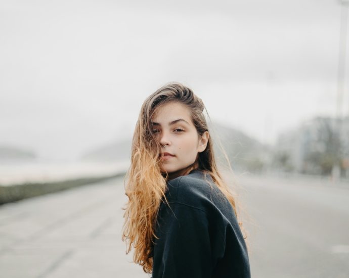 A young woman gazes towards the viewer.