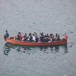 People are riding in a boat on the water.