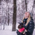 woman holding dog while looking up