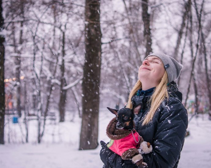 woman holding dog while looking up