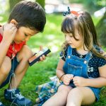 girl in blue denim button up vest holding smartphone