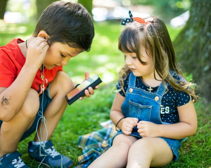 girl in blue denim button up vest holding smartphone
