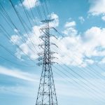 black electric tower under blue sky and white clouds during daytime