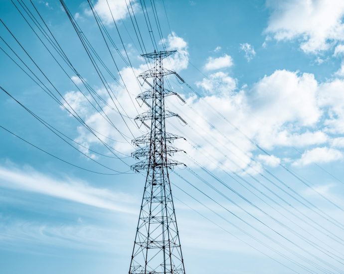 black electric tower under blue sky and white clouds during daytime