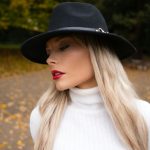 Woman wearing a black fedora and white turtleneck
