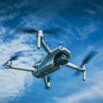 white and black drone flying under blue sky during daytime