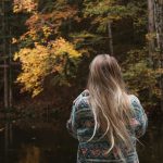 A woman standing in front of a body of water