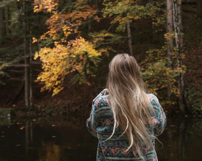 A woman standing in front of a body of water