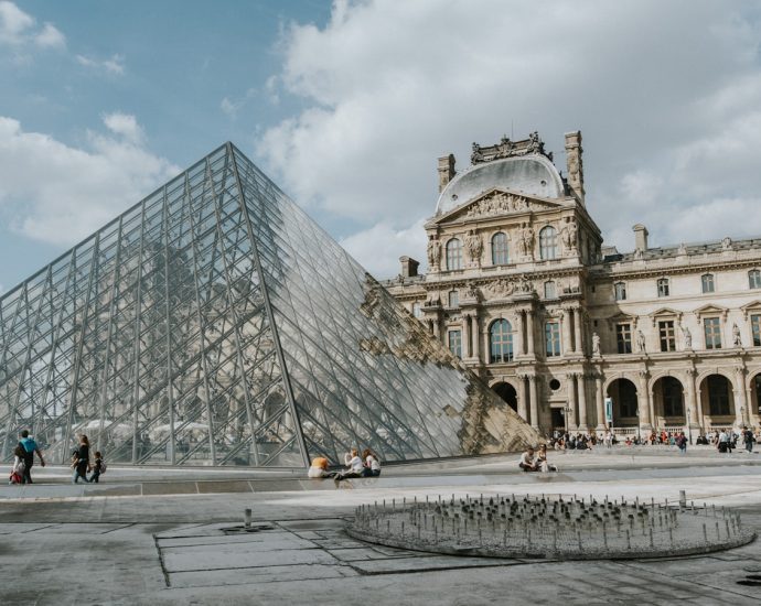 a glass pyramid in front of Louvre