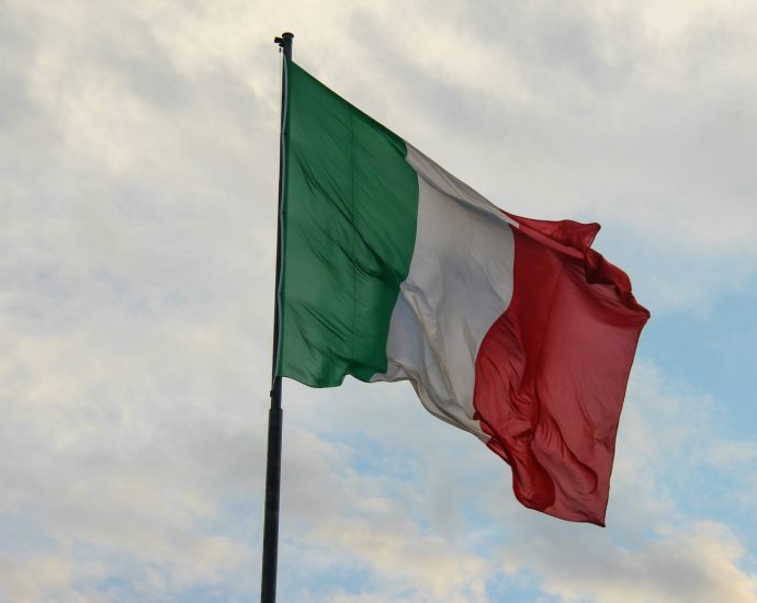 a couple of flags on a flagpole