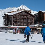 a couple of people walking across a snow covered field