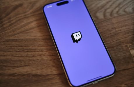 A cell phone with a purple background and a black sticker on the back of