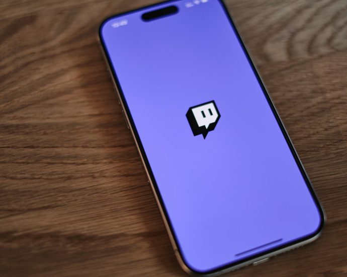 A cell phone with a purple background and a black sticker on the back of