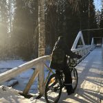 a person riding a bike on a bridge in the snow