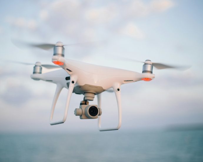close up photography of drone flying over body of water at daytime