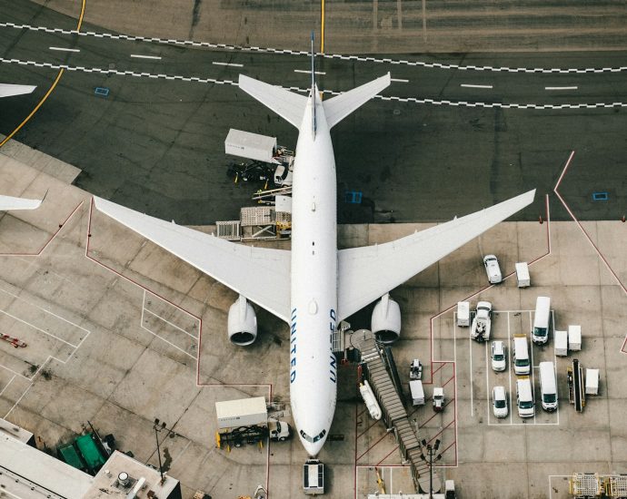 white and blue airplane on airport during daytime