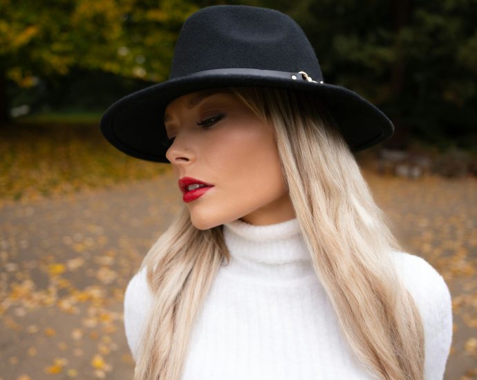 Woman wearing a black fedora and white turtleneck