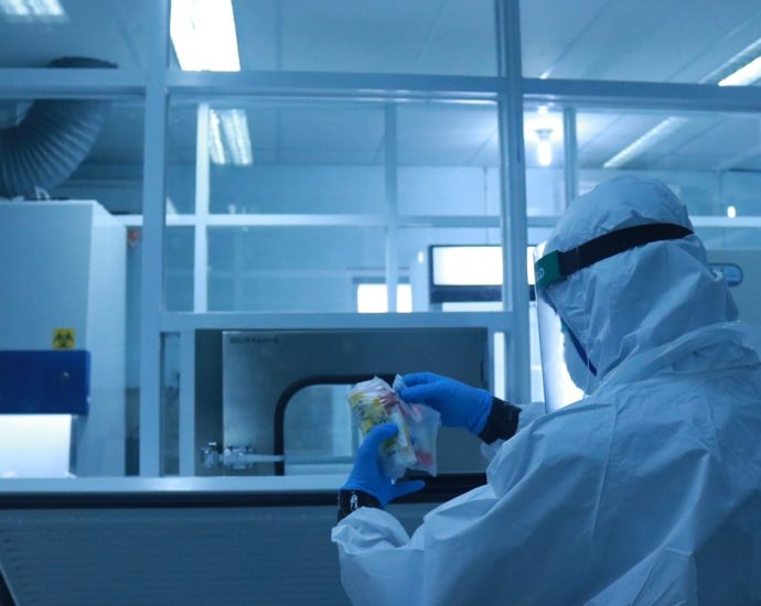 man in white dress shirt holding clear plastic bottle