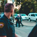 Police officer monitoring a street scene with patrol vehicles in Wheeling, WV.