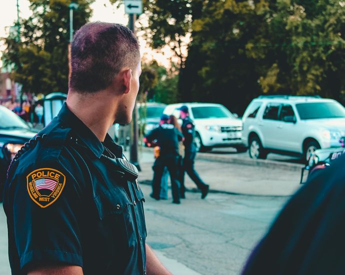 Police officer monitoring a street scene with patrol vehicles in Wheeling, WV.
