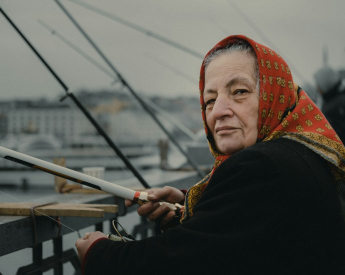 woman fishing on bridge during daytime