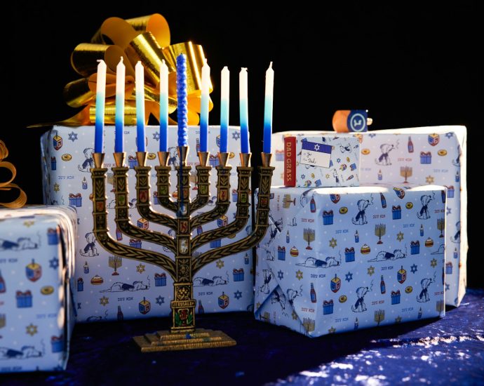 a lit menorah and gift boxes on a table