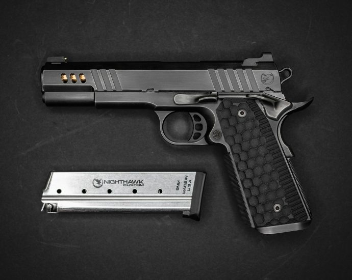 a gun and a knife on a black surface