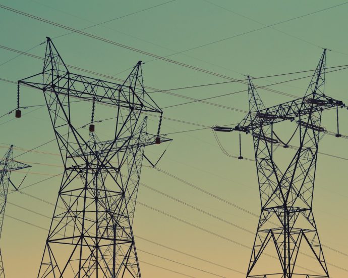 black transmission towers under green sky