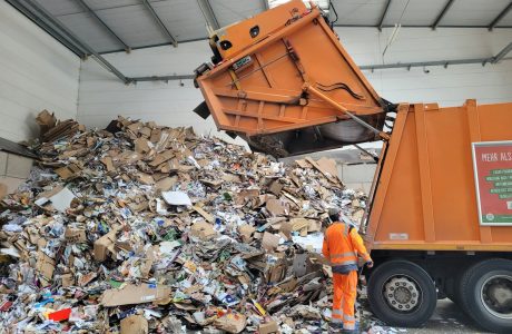 a man standing next to a pile of trash