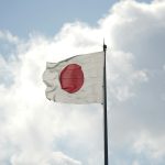 a white and red flag flying in the sky