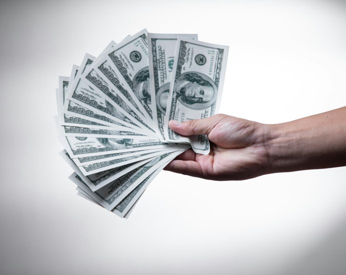 person holding 100 US Dollar banknote