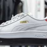 a white and red puma sneakers sitting on top of a table