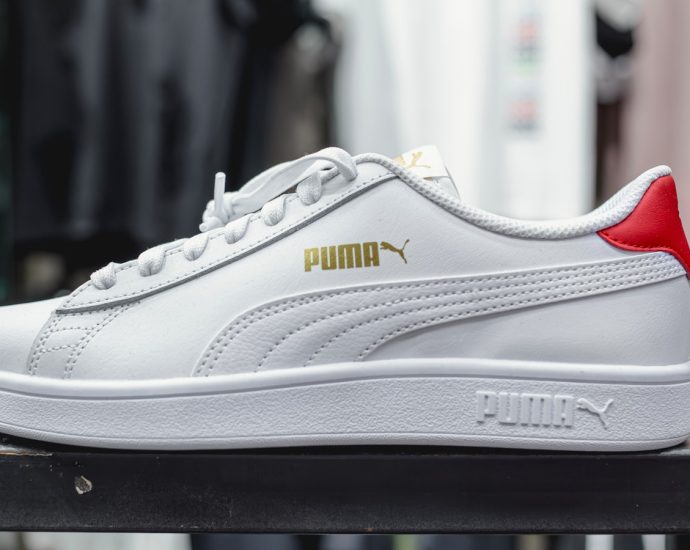 a white and red puma sneakers sitting on top of a table