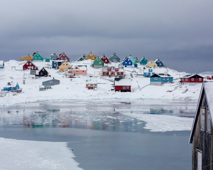 view photography of assorted-color houses near pond during daytime