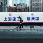 A woman crossing a street in front of a large billboard