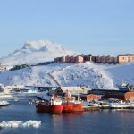 red and white ship on sea near mountain during daytime