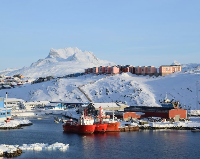 red and white ship on sea near mountain during daytime
