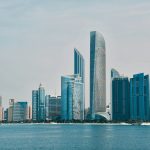 a city skyline with a body of water in the foreground