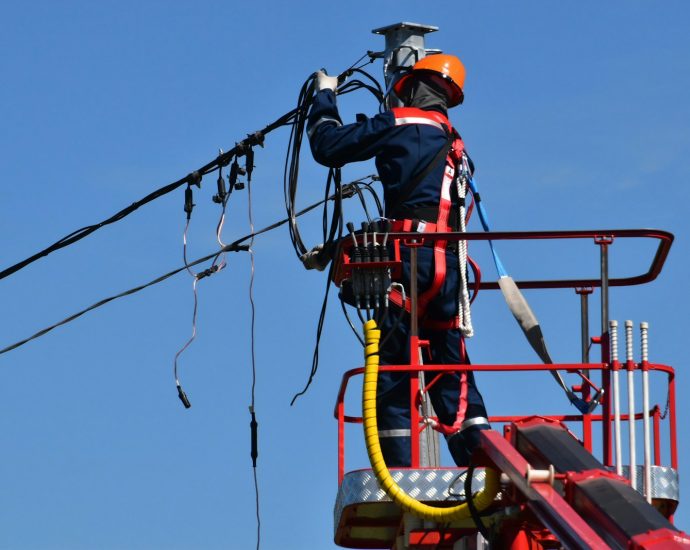 man in red and black jacket wearing orange helmet